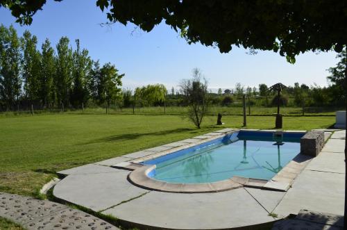 a swimming pool in the middle of a grass field at Casa con gran parque y pileta in General Alvear