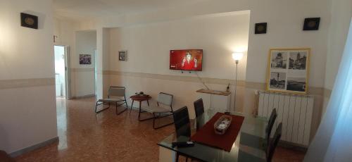 バーリにあるAppartamento Levanteのリビングルーム(テーブル、椅子、壁掛けテレビ付)