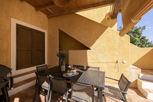 een tafel en stoelen op de patio van een huis bij Can Noves - Villa de 5 suites 28 y 58 in Sant Francesc Xavier