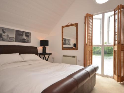 a bedroom with a large bed and a mirror at 3 Bed in South Cerney HIC06 in South Cerney