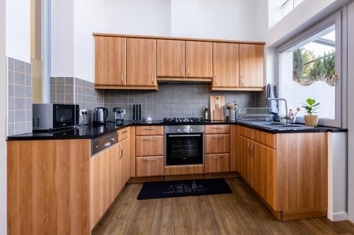 a kitchen with wooden cabinets and black counter tops at House of Lara in Brussels