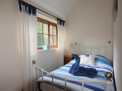 a bedroom with a bed with a blue stuffed animal on it at 2 Bed in Thetford 64075 in East Harling