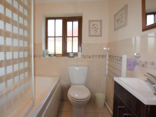 a bathroom with a toilet and a tub and a sink at 2 Bed in Thetford 64075 in East Harling