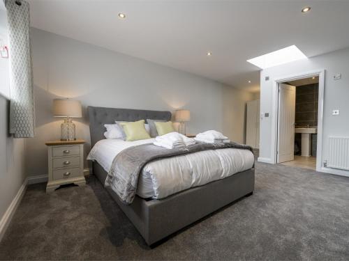 1 dormitorio con 1 cama grande con sábanas blancas y almohadas amarillas en 3 Bed in Mundesley KT057 en Mundesley