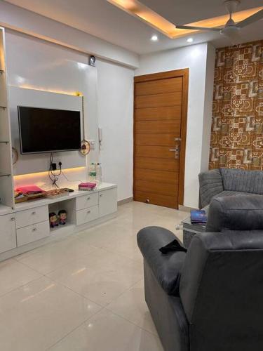 a living room with a couch and a flat screen tv at Charming Retreat in New Delhi