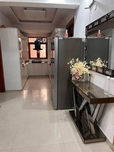 a large kitchen with a counter with flowers on it at Charming Retreat in New Delhi