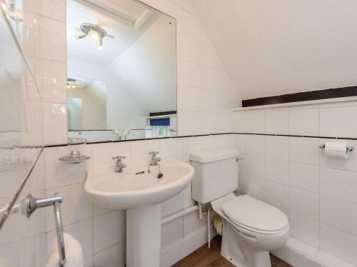 a white bathroom with a toilet and a sink at 1 Bed in Tenterden 66342 in Tenterden