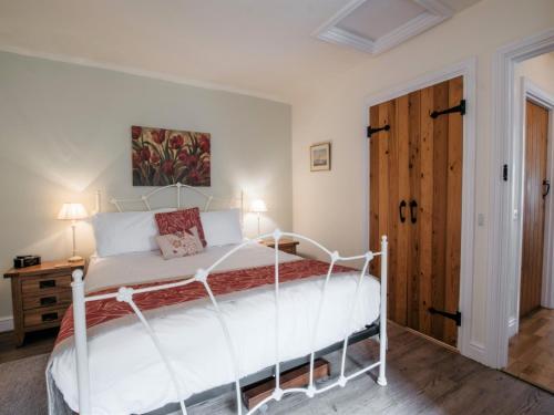 a bedroom with a white bed and a wooden door at 1 bed in Bedale G0094 in Crakehall
