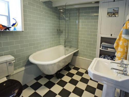 a bathroom with a bath tub and a sink at 2 Bed in Robin Hoods Bay G0085 in Robin Hood's Bay