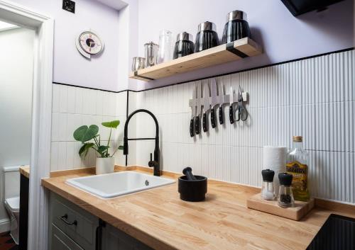 a kitchen with a sink and a counter with utensils at 72 - Quirky One Bed Property in the Norwich Lanes in Norwich