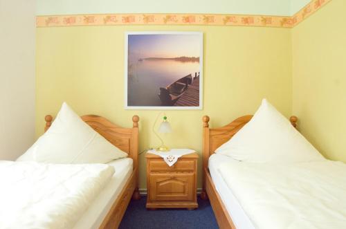 a bedroom with two beds and a table with a lamp at Pension Am Alten Markt in Halle an der Saale