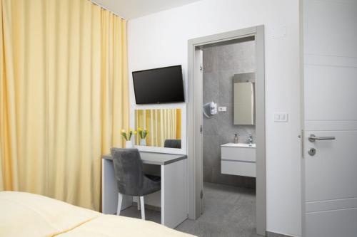 a hotel room with a desk and a television at Villa Tiki in Medulin for 16 person with heated pool & sauna only 1 km from the beach in Medulin