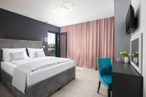a bedroom with a large bed and a blue chair at Villa Tiki in Medulin for 16 person with heated pool & sauna only 1 km from the beach in Medulin