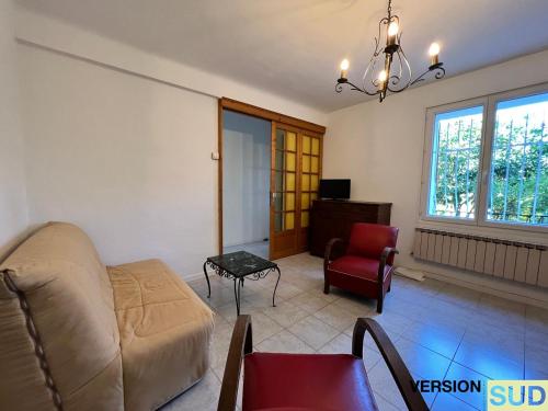 sala de estar con sofá y silla en Version SUD Lumineuse Bas Maison avec jardin, en Toulon
