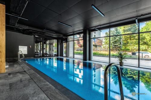 a large swimming pool with windows in a building at UNIA ART Apartament 61 - BASEN, SPA in Lublin