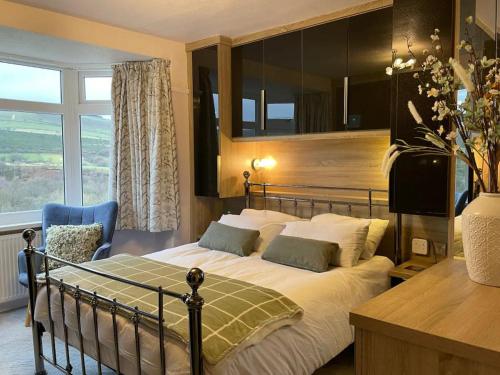 1 dormitorio con cama y ventana grande en 3BR Pet and Bike Friendly Cosy Haven Pass the Keys en Glossop