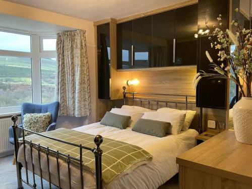 a bedroom with a bed and a large window at Glossop Retreat - Pet Friendly Perfect for 6 in Glossop