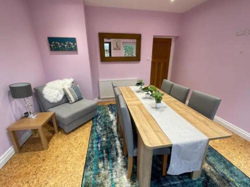a dining room with a table and a couch at Glossop Retreat - Pet Friendly Perfect for 6 in Glossop