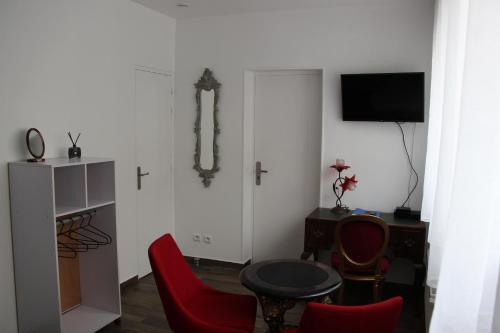 sala de estar con mesa y sillas rojas en PARIS de FLORE Stane, en Malakoff