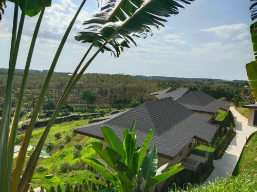 a house with a black roof and a palm tree at Khaolak Blue Sky Villa in Khao Lak