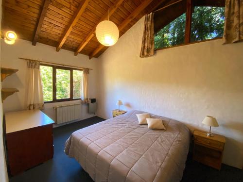 - une chambre avec un lit, un bureau et des fenêtres dans l'établissement Tu Apart en Bariloche 27, à San Carlos de Bariloche