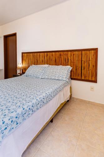 a bedroom with a large bed with a wooden headboard at Moriah Maceió Beach Hotel in Maceió
