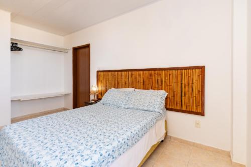 a bedroom with a bed and a wooden headboard at Moriah Maceió Beach Hotel in Maceió
