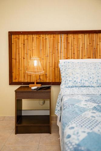 a bedroom with a bed and a lamp on a table at Moriah Maceió Beach Hotel in Maceió