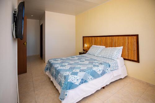 a bedroom with a bed with a blue and white quilt at Moriah Maceió Beach Hotel in Maceió