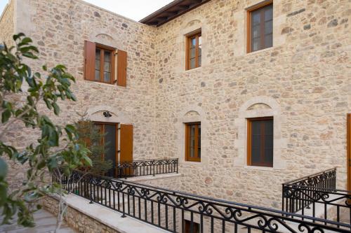 an external view of a stone building with a black fence at Μikri Arktos Boutique Hotel in Dhimitsana