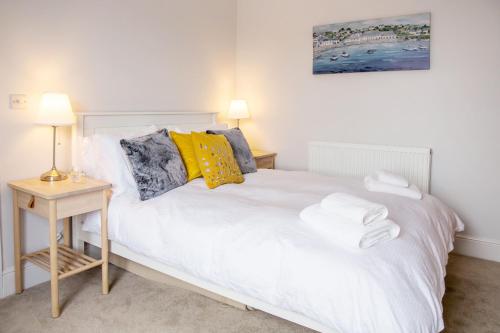 um quarto com uma cama branca e uma mesa de cabeceira em Eastholme, style and luxury in Southwold, Suffolk em Southwold