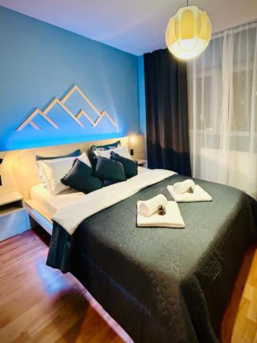 a bedroom with a bed with two towels on it at Blue Mountain Residence in Braşov