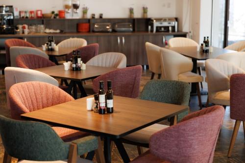 um restaurante com mesas e cadeiras com garrafas em Suru Hotel & Restaurant em Buşteni