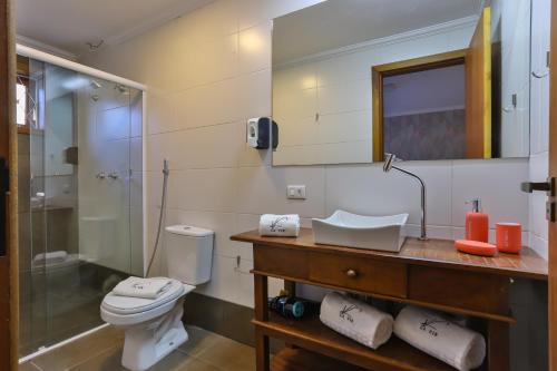 a bathroom with a toilet and a sink and a shower at La Vita Pousada de Charme in Campos do Jordão