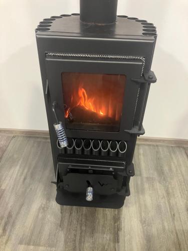 a black stove with a fire in a room at Domeček Janov in Janov