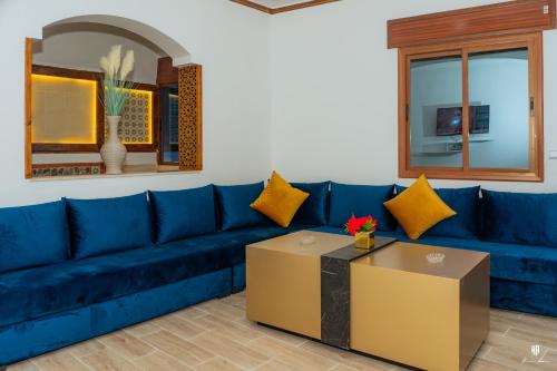 a blue couch in a living room with a table at DAR BLANCA in Chefchaouene