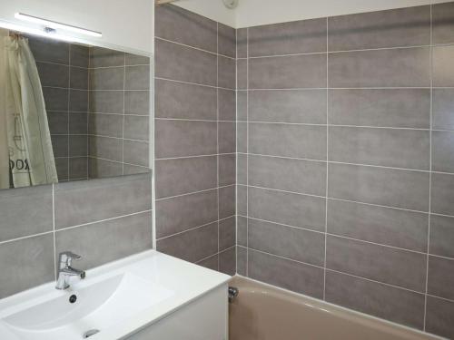 uma casa de banho com um lavatório, um espelho e uma banheira em Appartement Les Orres, 1 pièce, 4 personnes - FR-1-322-122 em Les Orres