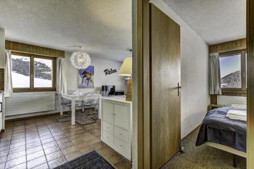a bedroom with a bed and a desk and a table at Appartement Diana 33 in La Tzoumaz