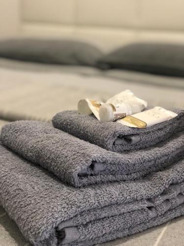a pile of towels with a toothbrush and a tooth paste at B&B BELLAMI' in Tuglie