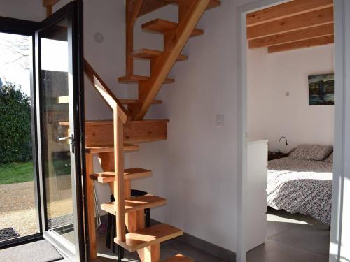- un escalier en bois dans une chambre avec un lit dans l'établissement Maison neuve avec jardin à 150m de la mer à Trégastel, proche port et plage - FR-1-368-145, à Trégastel