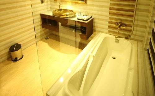 a bathroom with a bath tub and a sink at Hotel X Rajshahi in Rājshāhi