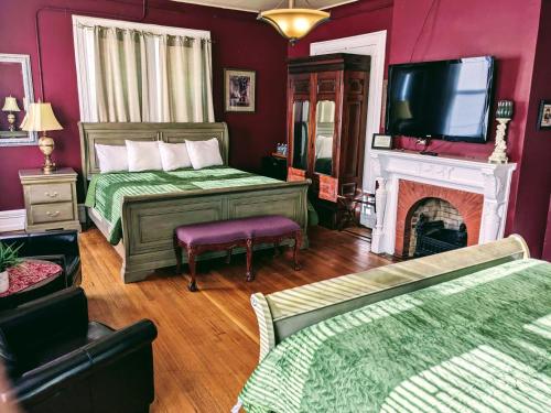 a bedroom with a bed and a tv and a fireplace at Chelsea Pub and Inn in Atlantic City