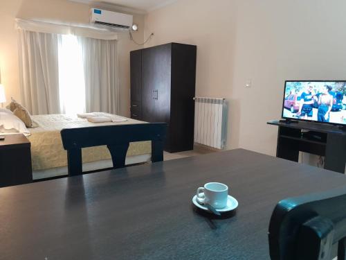 um quarto com uma cama e uma chávena de café numa mesa em Antares Apartments em Campana