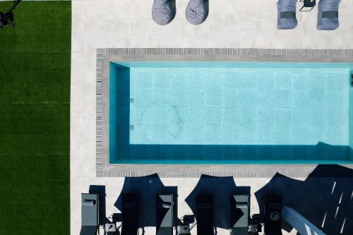 vista sul soffitto di una piscina con sedie di Del Sur Luxury Villa, Absolute Privacy & Comfort, By ThinkVilla a Lefkogeia