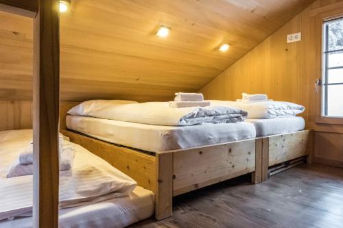A bed or beds in a room at Eigerhome - The Cottage mit Wellness - GRIWA RENT AG