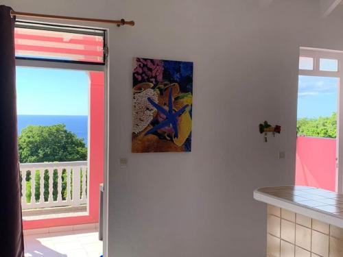 a kitchen with a view of the ocean from a balcony at Terrasse des Manguiers : logement indépendant in Pointe-Noire