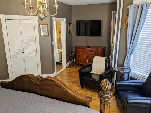 a room with a bed and a couch and a tv at Chelsea Pub and Inn in Atlantic City