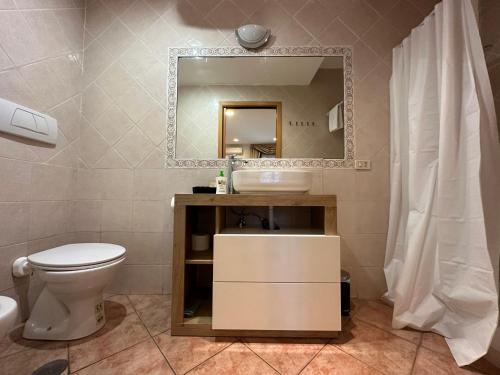 ein Badezimmer mit einem WC, einem Waschbecken und einem Spiegel in der Unterkunft Residence Villa il sogno in Rom