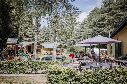 un grupo de personas sentadas en una mesa con un paraguas en Camping Siësta, en Lille