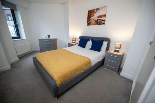 a bedroom with a large bed with blue pillows at Contemporary 1 Bed Apartment in Bedford